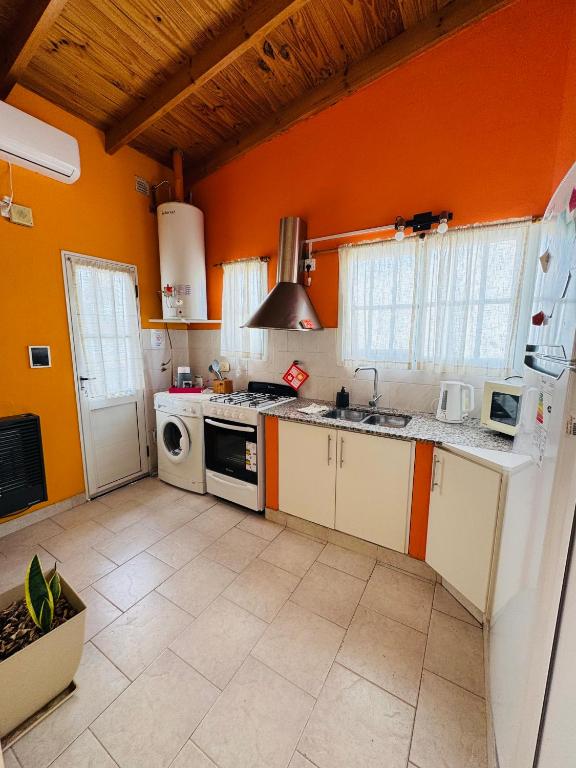 a kitchen with orange walls and a stove top oven at Departamento Centro RIOyMAR in Viedma