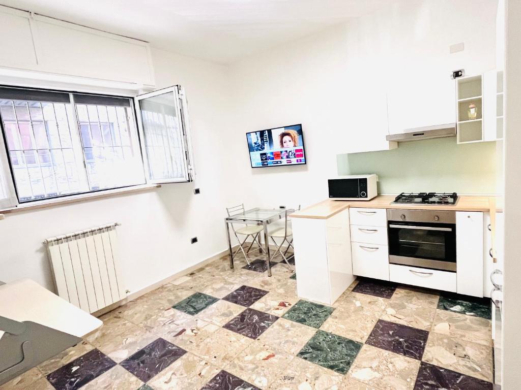 a kitchen with white cabinets and a table in it at Roxy House Sesto San Giovanni 300mt MetroRondó in Sesto San Giovanni