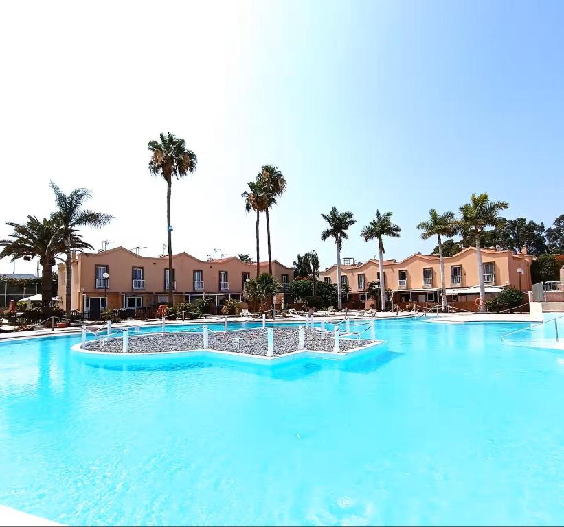 een groot zwembad met blauw water in een resort bij Green Holiday Island in Maspalomas