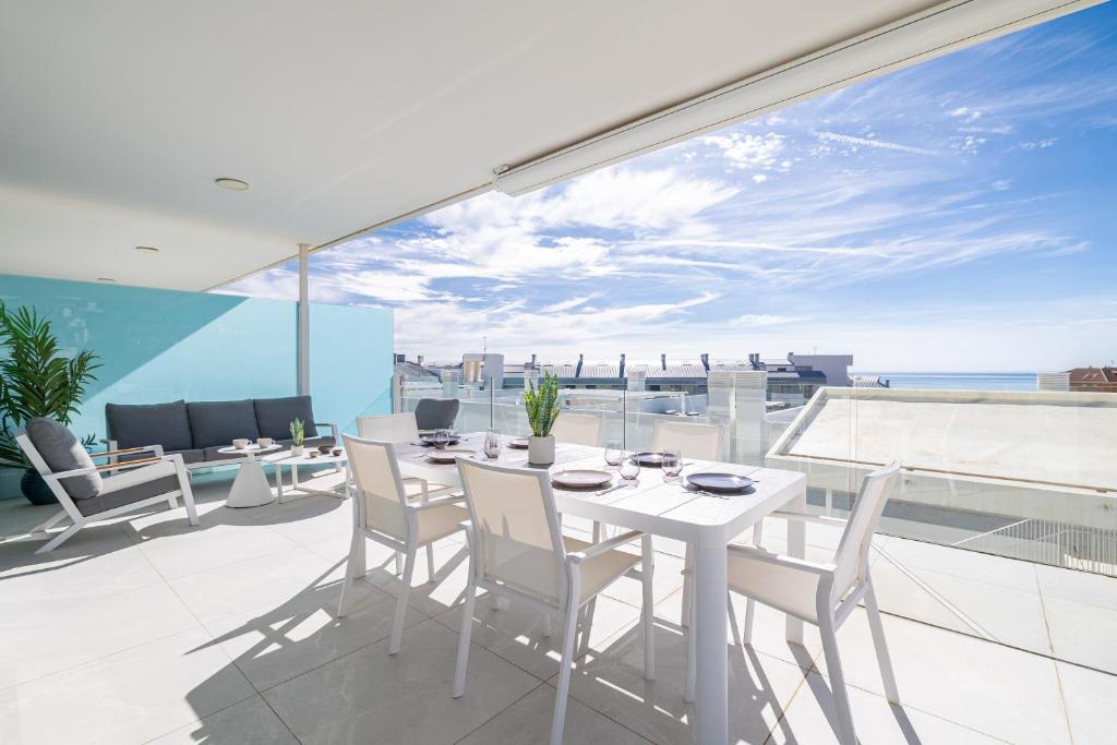 a white table and chairs on a balcony with a view at Med2holidays in Fuengirola