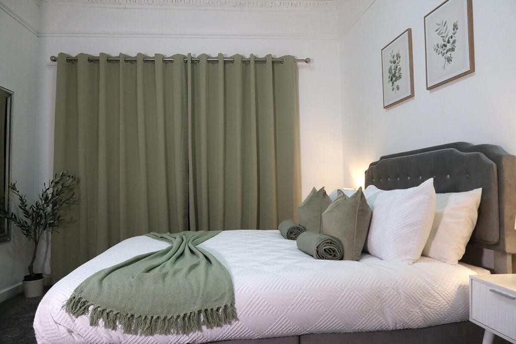 een slaapkamer met een groot bed en groene gordijnen bij Henderson Home Sleeps 3 with Allocated Parking in Pallion