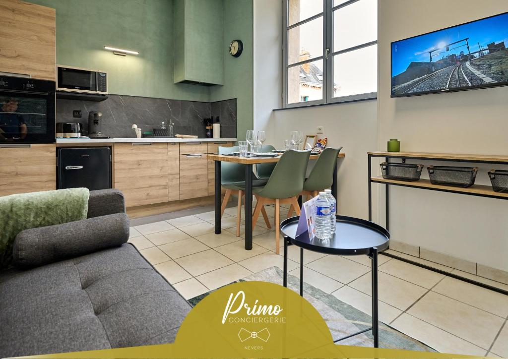 a kitchen and living room with a table and a couch at Ô 14 juillet Proche quartier historique, hyper centre in Nevers
