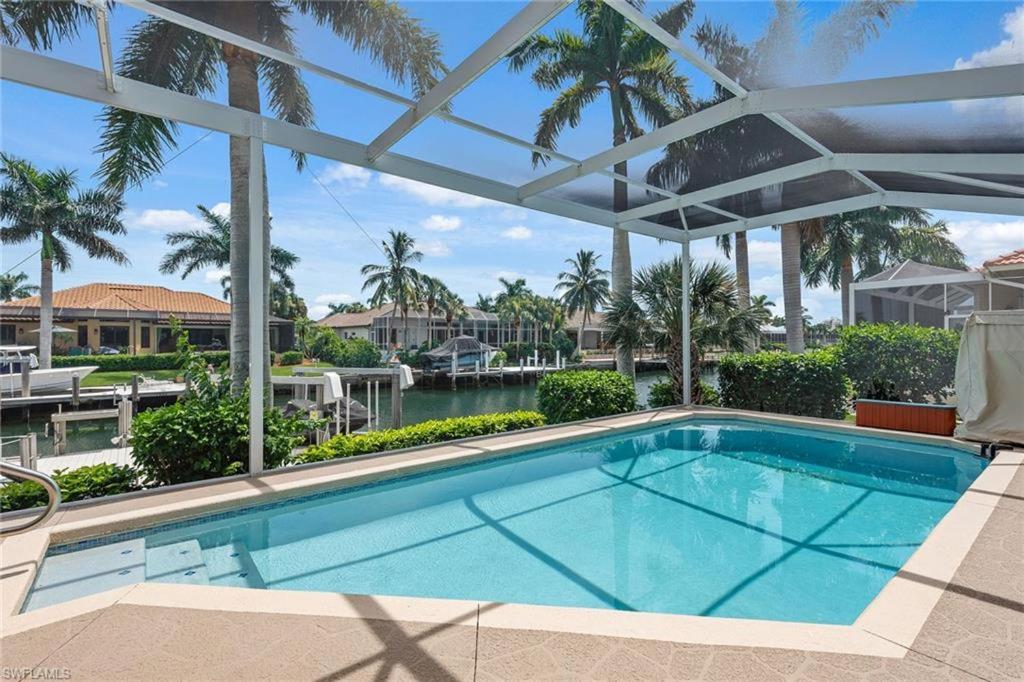 a large swimming pool with a swimming poolvisor at New Listing Updated Waterfront I Walk to Beach in Marco Island