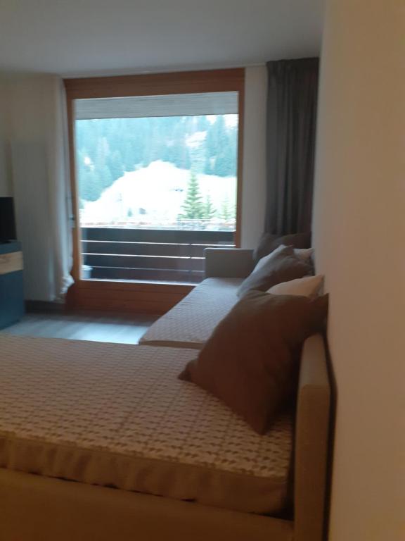 a bedroom with two beds and a large window at Appartamento Valfurva 15 in Santa Caterina Valfurva