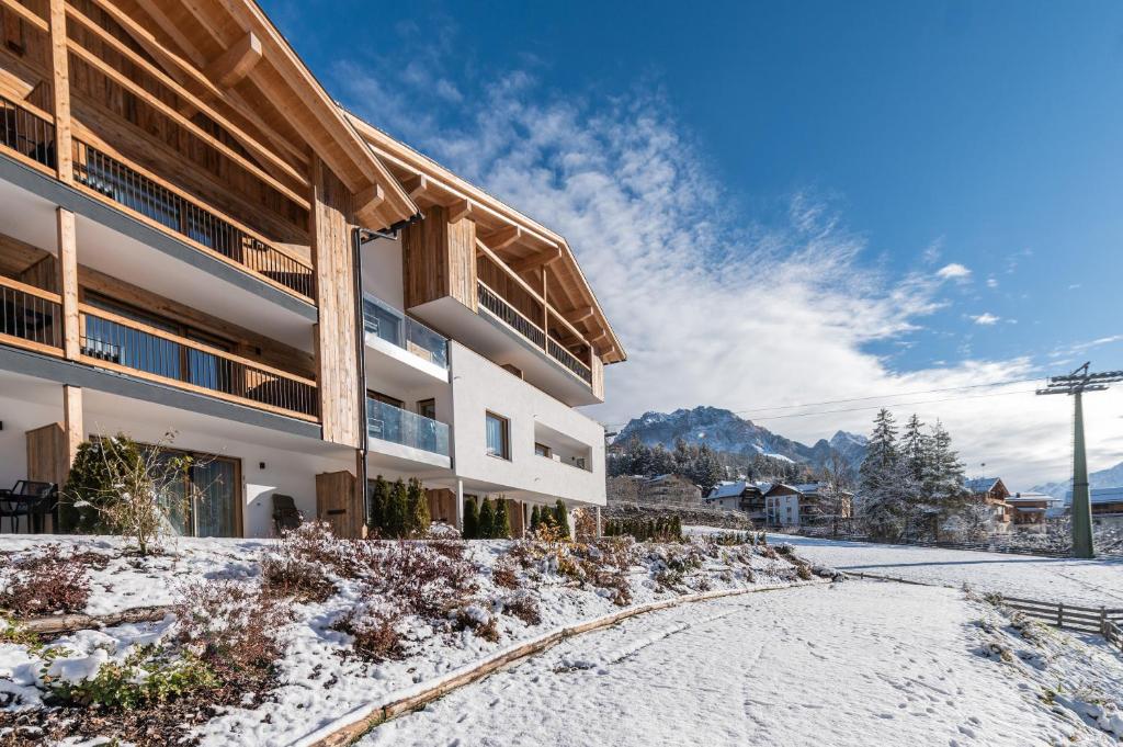 a snow covered road in front of a building at CHALET NORA in San Vigilio Di Marebbe
