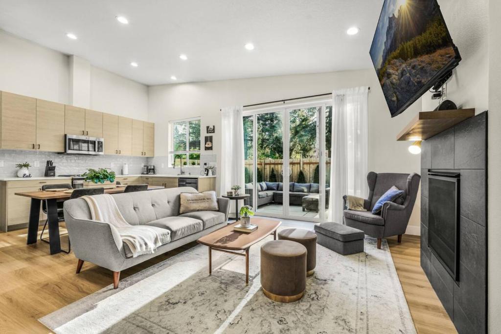 a living room with a couch and a table at Amazing and Comfy Home With A Fire Place and Big Backyard in Orchards