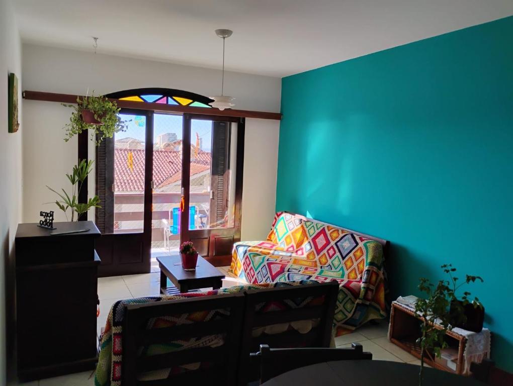 ein Wohnzimmer mit einem Sofa und einer blauen Wand in der Unterkunft Xangrilá, um paraíso perto da praia in Xangri-lá