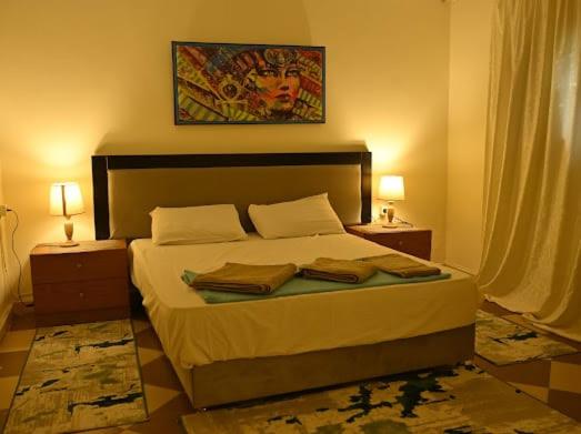 une chambre avec un grand lit avec deux tables de nuit dans l'établissement Villa Sela Gem, au Caire