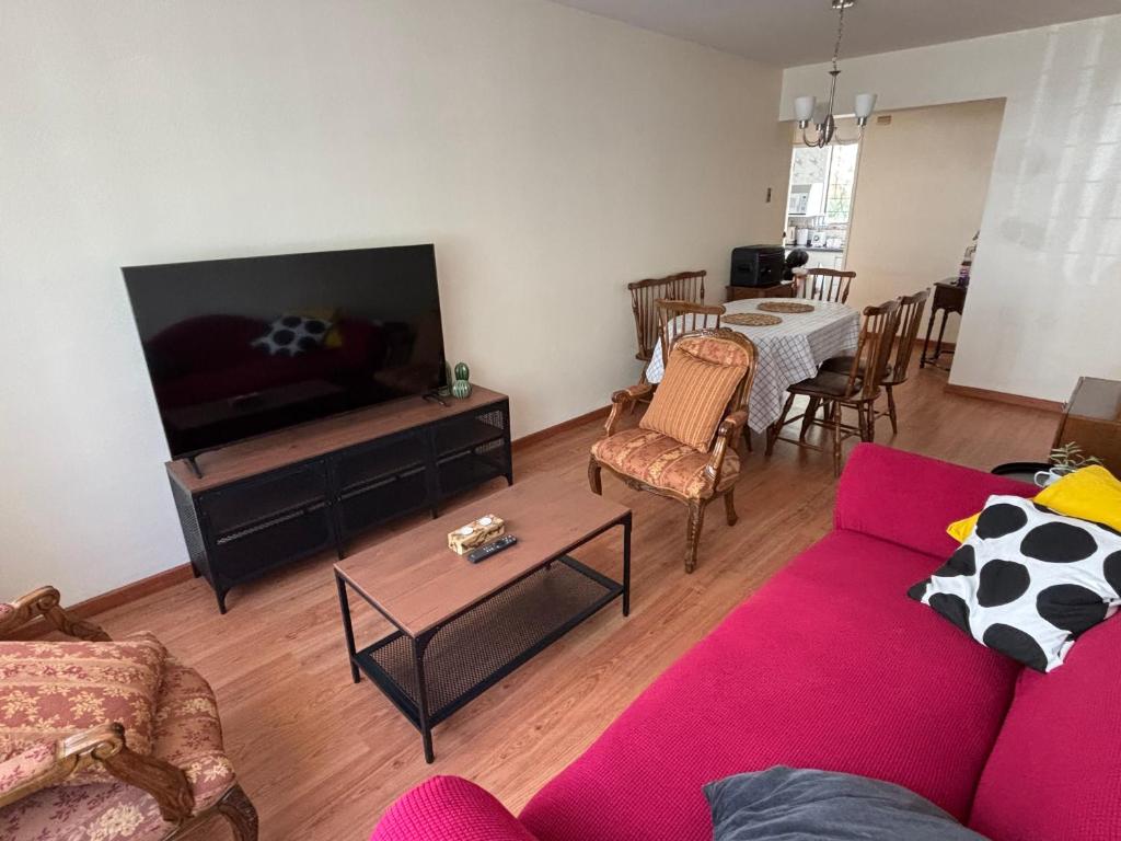 a living room with a red couch and a tv at Hermoso departamento en Viña del Mar in Viña del Mar