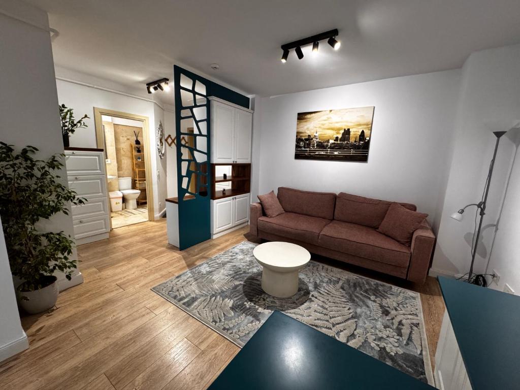 a living room with a couch and a table at Newton Flat Apartment in Văleni