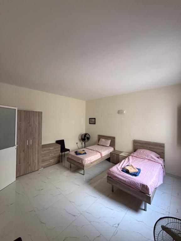 a bedroom with two beds and a tv in it at Fgura Spacious Apartments in Tal-Liedna