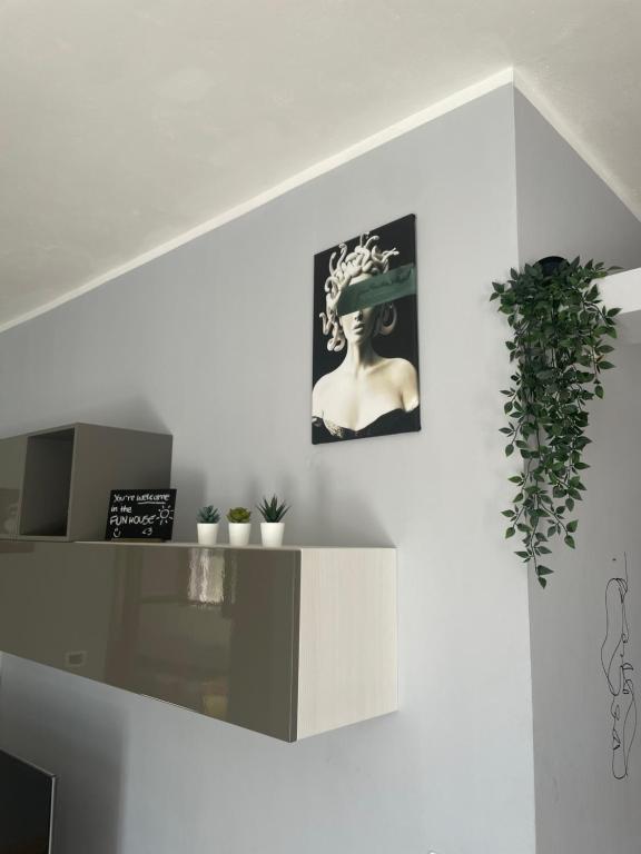 a white wall with a picture of a woman with a hat at Fun House in Trabia