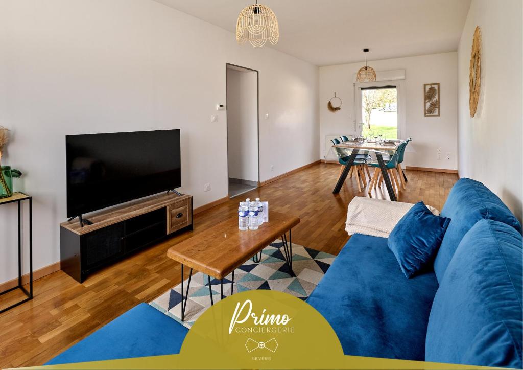 a living room with a blue couch and a tv at La Providence proche gare Primo Conciergerie in Nevers