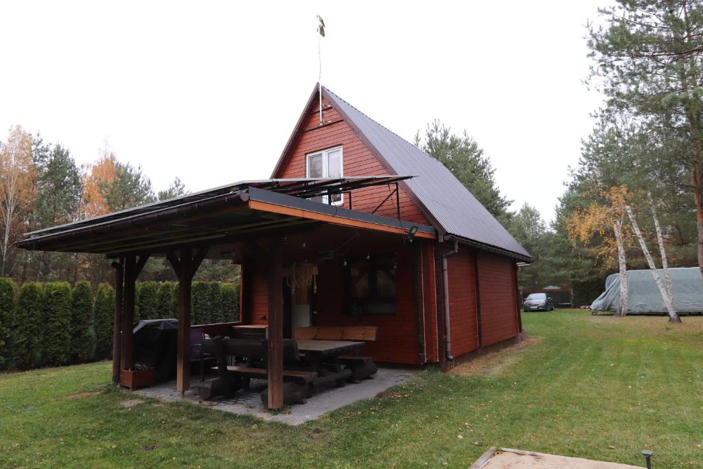a small red shed with a pitched roof at Całoroczny, drewniany domek przy lesie in Prażmów