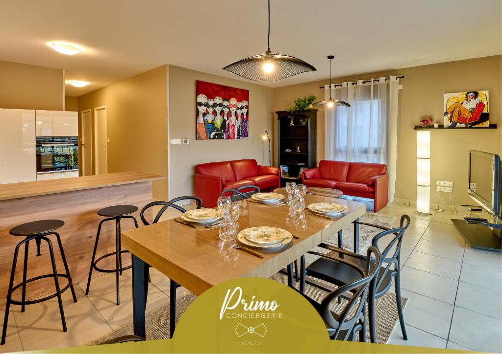 Un comedor y una sala de estar con mesa y sillas. en Le Manou, Appartement neuf avec terrasse, parking sous-terrain & ascenseur by PRIMO C0NCIERGERIE, en Nevers