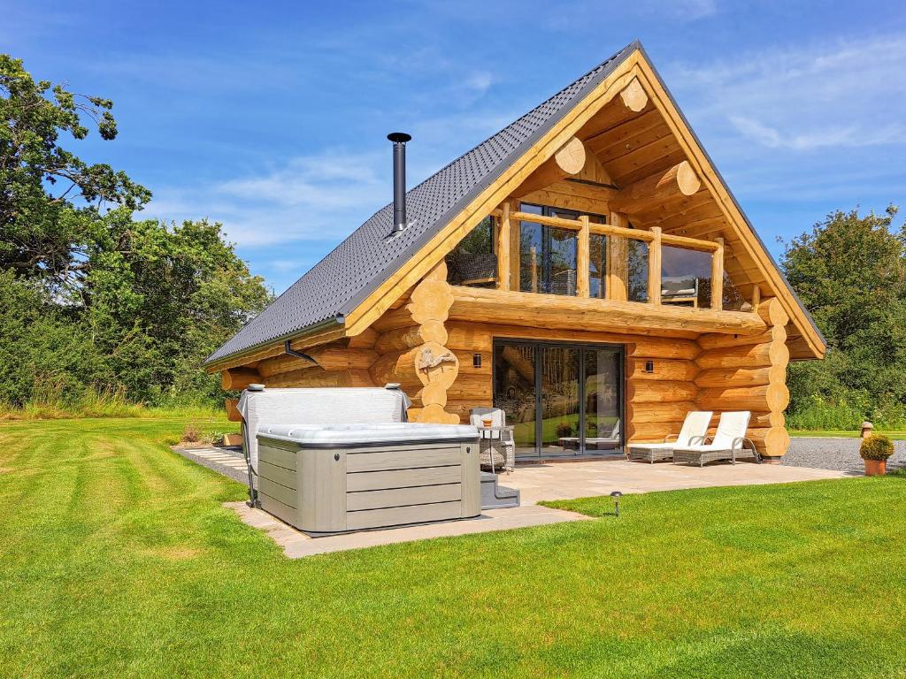a log cabin with a hot tub in the yard at Hope Hideaway 