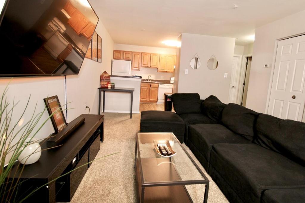 een woonkamer met een zwarte bank en een tafel bij Spacious 1BR with Full Kitchen & Laundry in Laurel