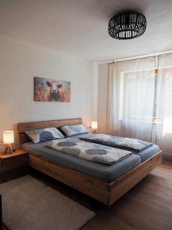 a bedroom with a large wooden bed with two lamps at Landglück in Tettnang