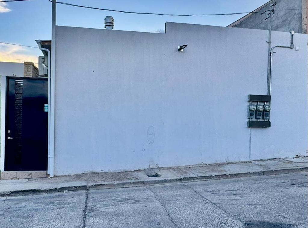 a white wall with two meters on the side of a building at Mini Suits Limpias y Confortables in Villa de Ojinaga
