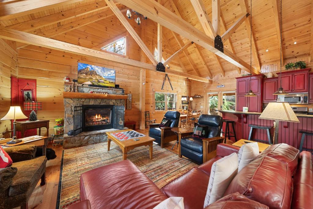 a living room with leather furniture and a fireplace at Sugars Cozy Cabin in Sugar Mountain