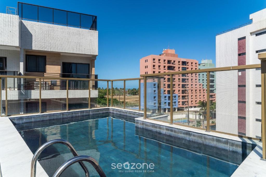 a swimming pool on the balcony of a building at Sua estadia a 350m da Praia em prédio c/ piscina na melhor localização de Cabedelo-PB | PTAs in Ilha da Restinga