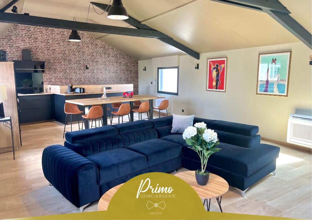 a living room with a blue couch and a table at Le Loft Manhattan, en centre ville, proche Sainte Bernadette avec Parking, PRIMO C0NCIERGERIE in Nevers