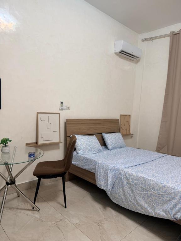 ブラザヴィルにあるEpayinayocgのベッドとガラスのテーブルのある寝室