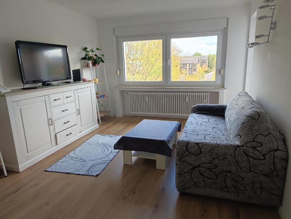 a living room with a couch and a flat screen tv at 2 Zimmer Apartement mit Balkon bei Düsseldorf in Erkrath