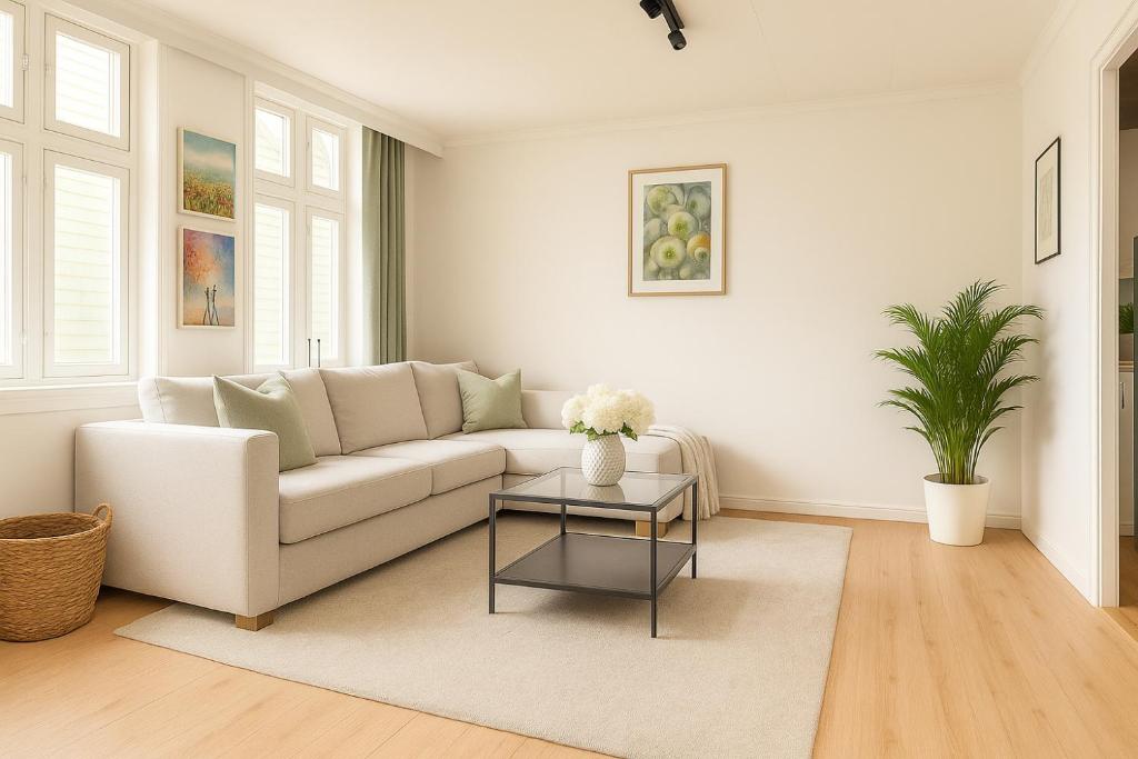 Una sala de estar con un sofá blanco y una mesa. en Delightful Bryggen Apartment - Norwegians Minimum Age 25, en Bergen