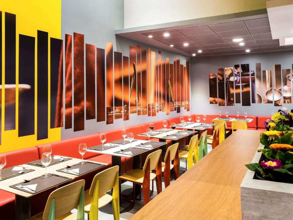 a dining room with long tables and yellow chairs at ibis Copiapo in Copiapó