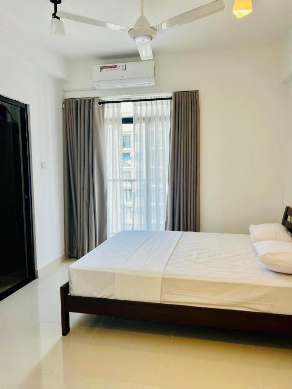 a bedroom with a large bed and a window at Bright 3-Bed Flat with Balcony with Great Value in Sri Jayewardenepura Kotte