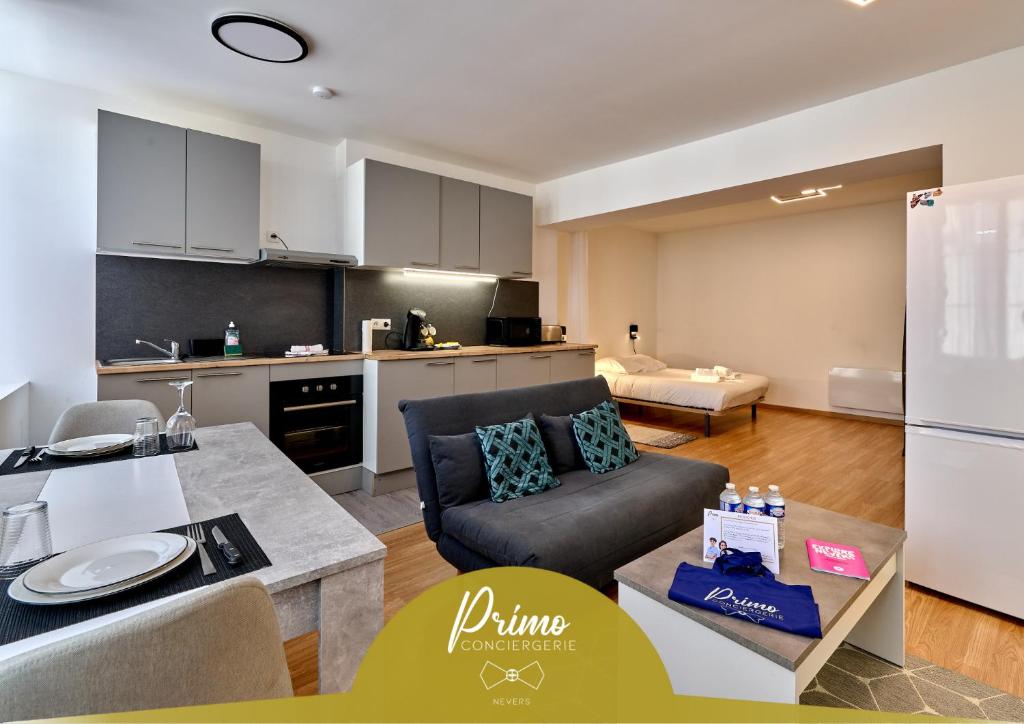 een woonkamer met een bank en een keuken bij Séjour tout confort en plein coeur de Nevers, studios Galet-Carbone ou Terra Cotta in Nevers