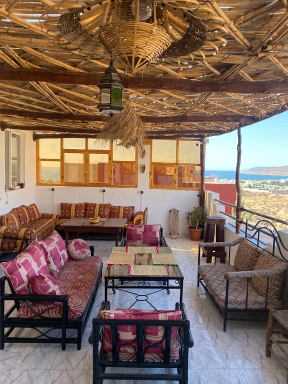 a living room with couches and a table at Red Carpet Surf Camp SURF , WORK & CONNECT in Tamraght Ouzdar