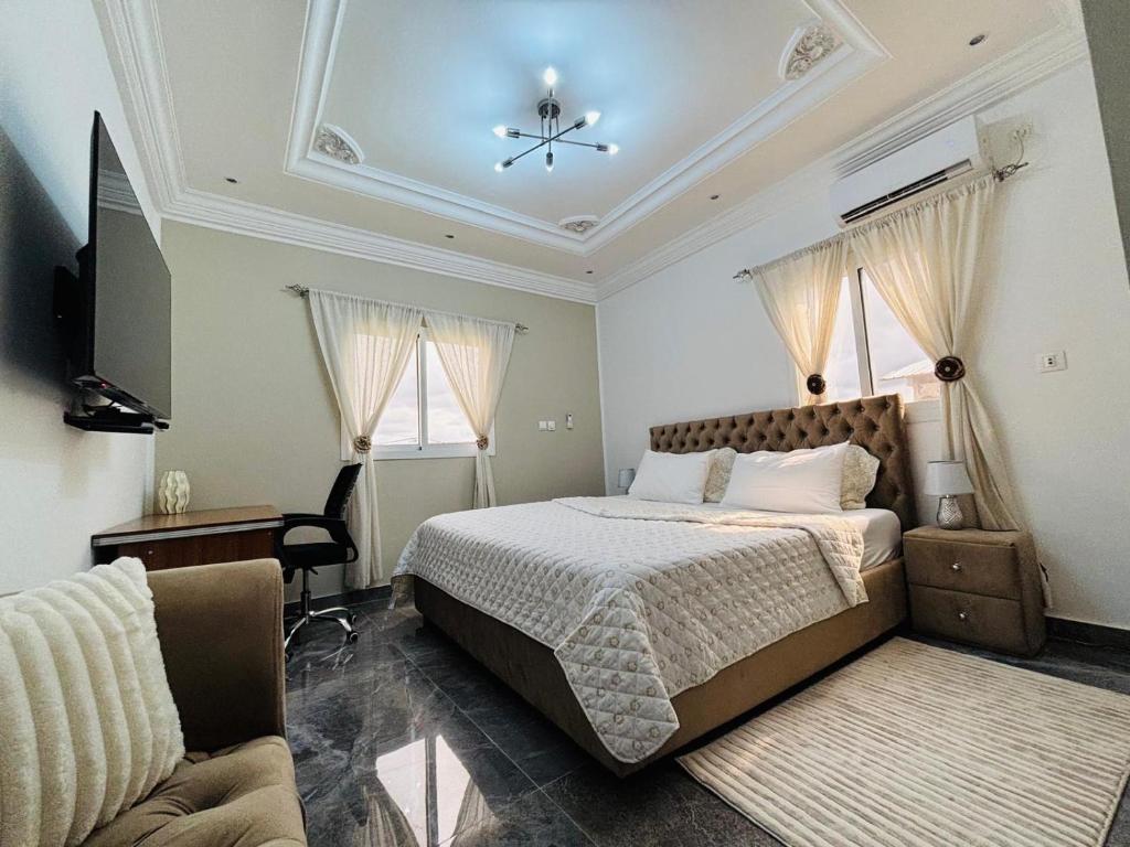 a bedroom with a bed and a television and a couch at Résidence Bethel in Libreville