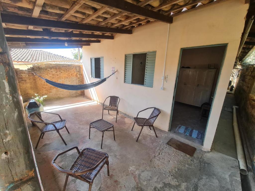 a group of chairs and a hammock on a patio at MAEVE Hostel in Goiás