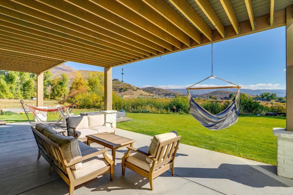 eine Veranda mit einer Hängematte und Stühlen sowie eine Terrasse in der Unterkunft Family Wasatch Mountain Fun! Spacious Utah Retreat in Mound City