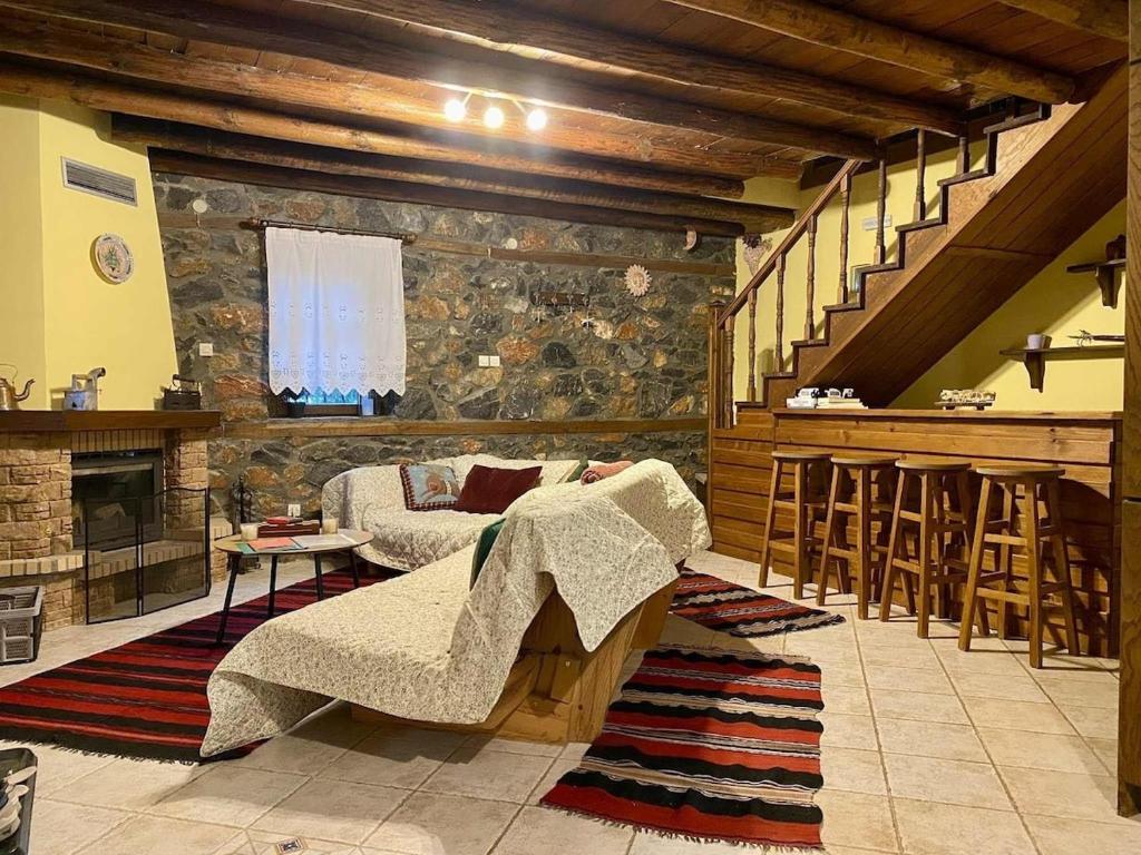 a living room with a couch and a stone wall at Elato Stone House in Panayítsa