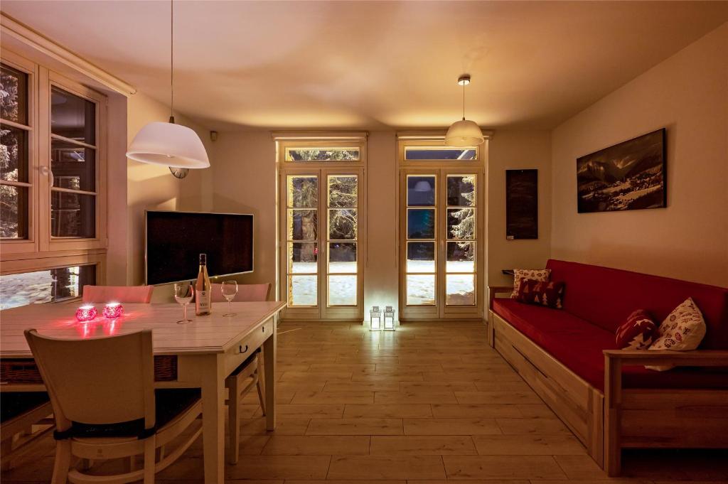 a living room with a table and a red couch at Horní Mísečky - I3 Pohodlný a teplý apartmán u sjezdovky in Horni Misecky