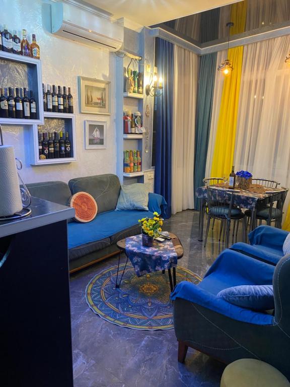 a living room with a blue couch and a table at Dea Apartments in Batumi