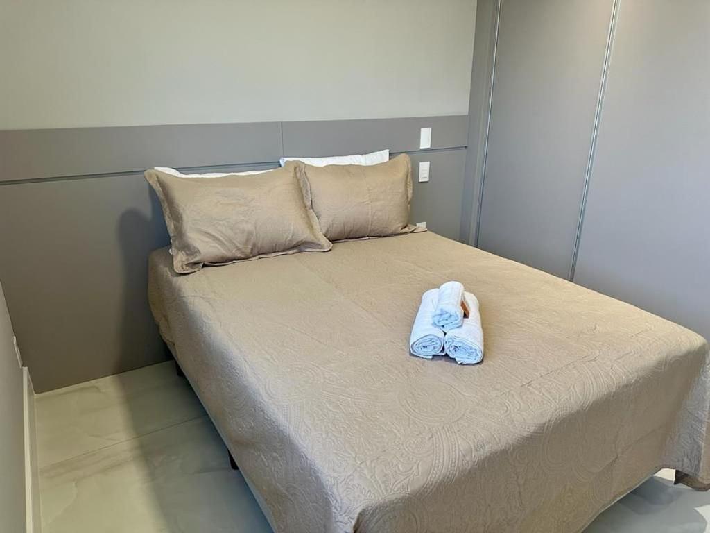 a bed with a pair of blue shoes on it at Apê no Belenzinho – Metrô Bresser / Pq. Belém in Sao Paulo