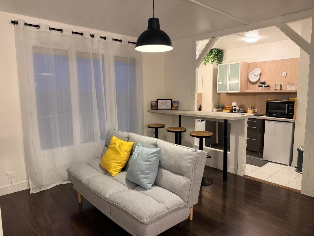 a living room with a couch and a kitchen at Studio aux portes d'Orly & Paris in Athis-Mons