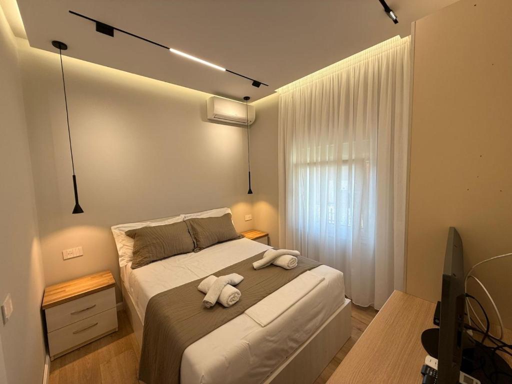 um quarto com uma cama com duas toalhas em TheCozy Home Tirana em Sauk