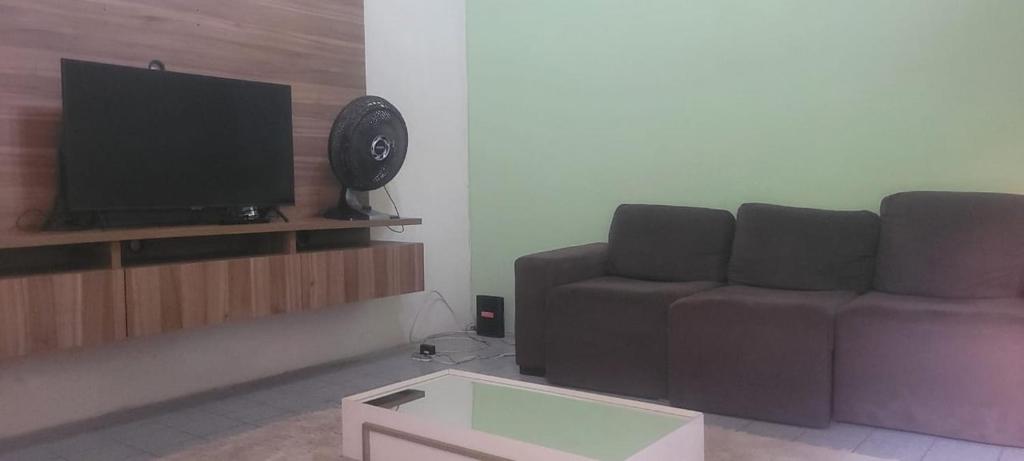 a living room with a couch and a flat screen tv at home in Belém cop 30 in Belém