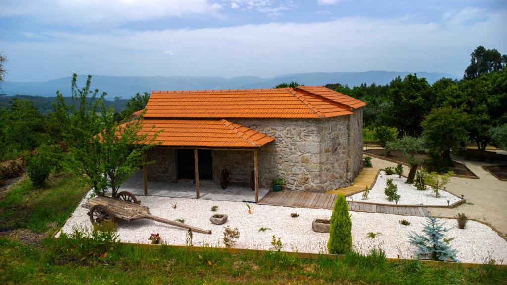 a small stone house with an orange roof at Quinta dos Castanheiros in Oliveira de Frades