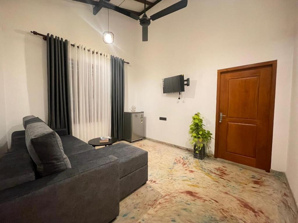 a living room with a couch and a tv at Harbor Moon in Hiriketiya
