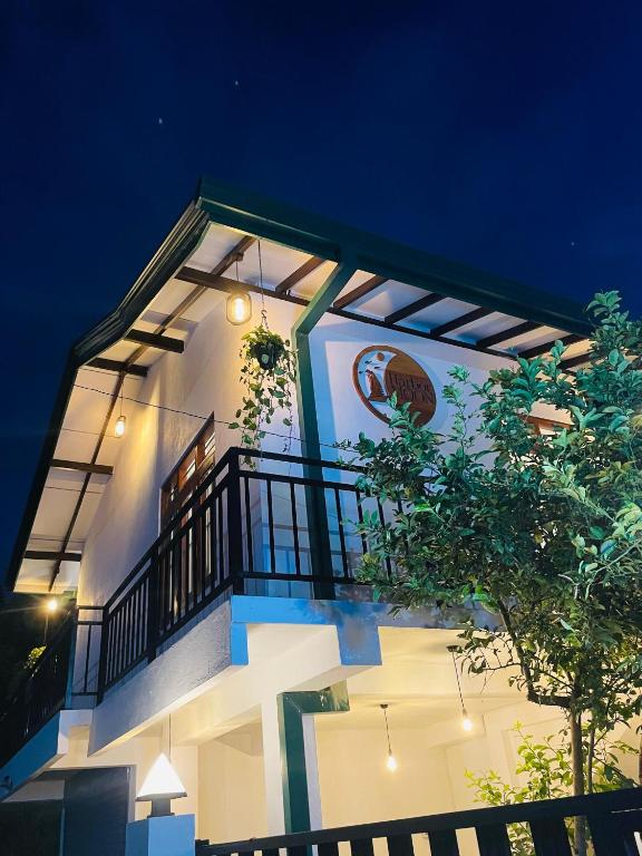 a white building with a balcony at night at Harbor Moon in Hiriketiya