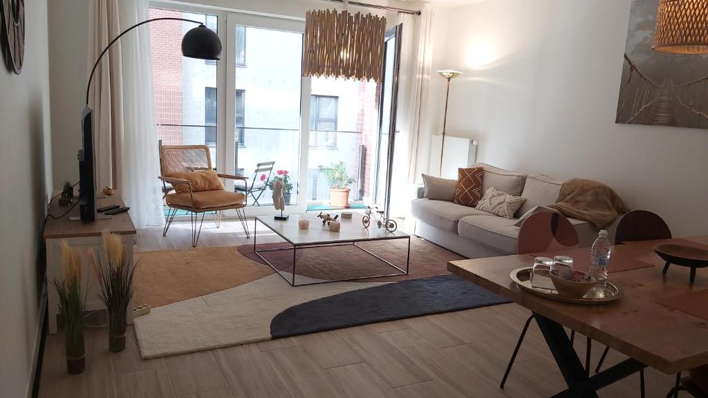 a living room with a couch and a table at Courbevoie lodge Louvain-la-Neuve in Louvain-la-Neuve