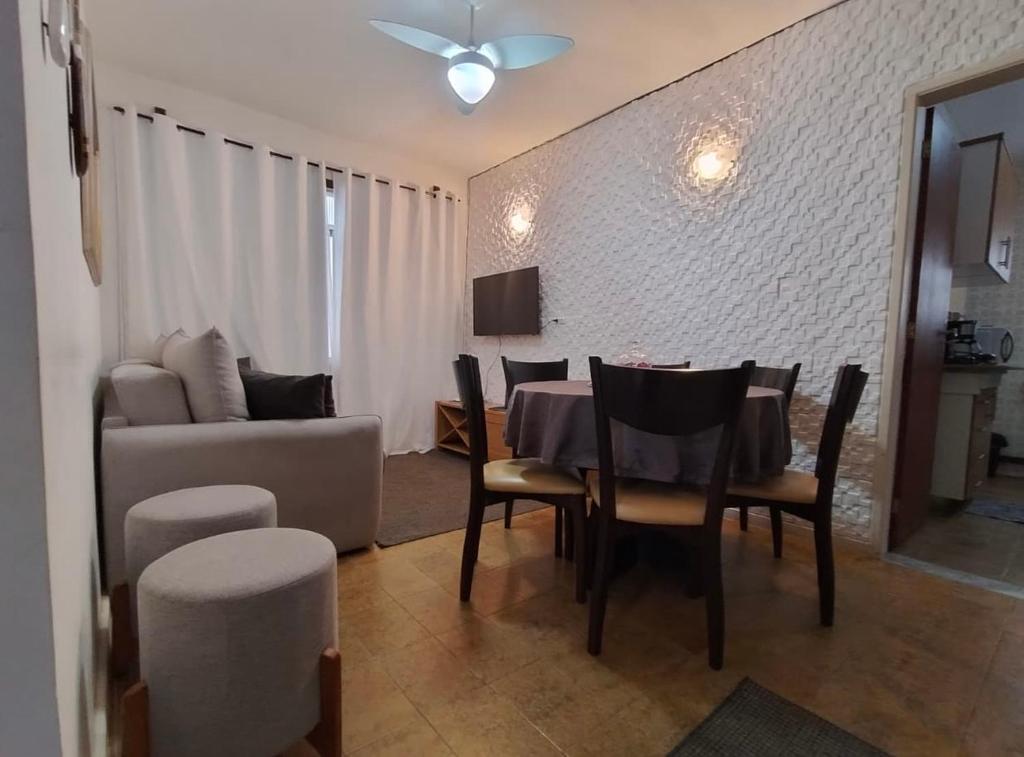 uma sala de jantar com mesa e sofá em Ap 100 mtrs da praia do forte em Cabo Frio