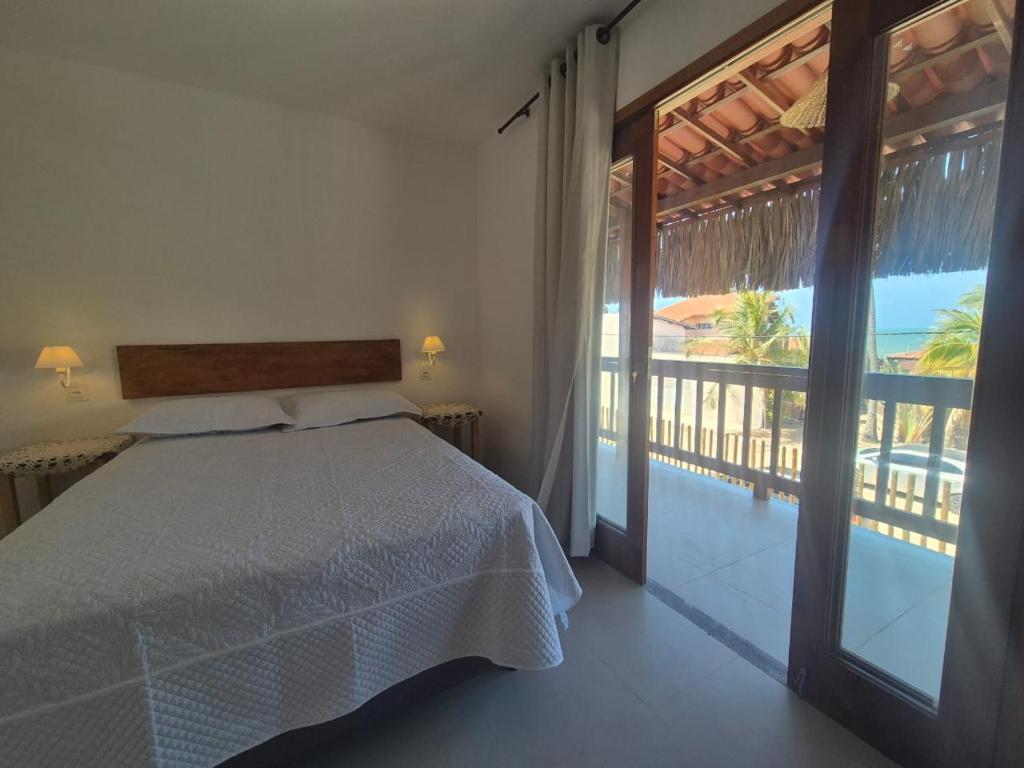 a bedroom with a bed and a view of the ocean at Pousada Janela dos Ventos in Caucaia
