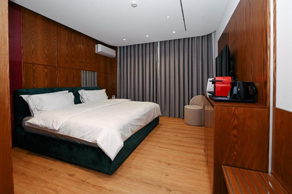 een slaapkamer met een bed en een televisie. bij Wilson On The Bllok in Tirana